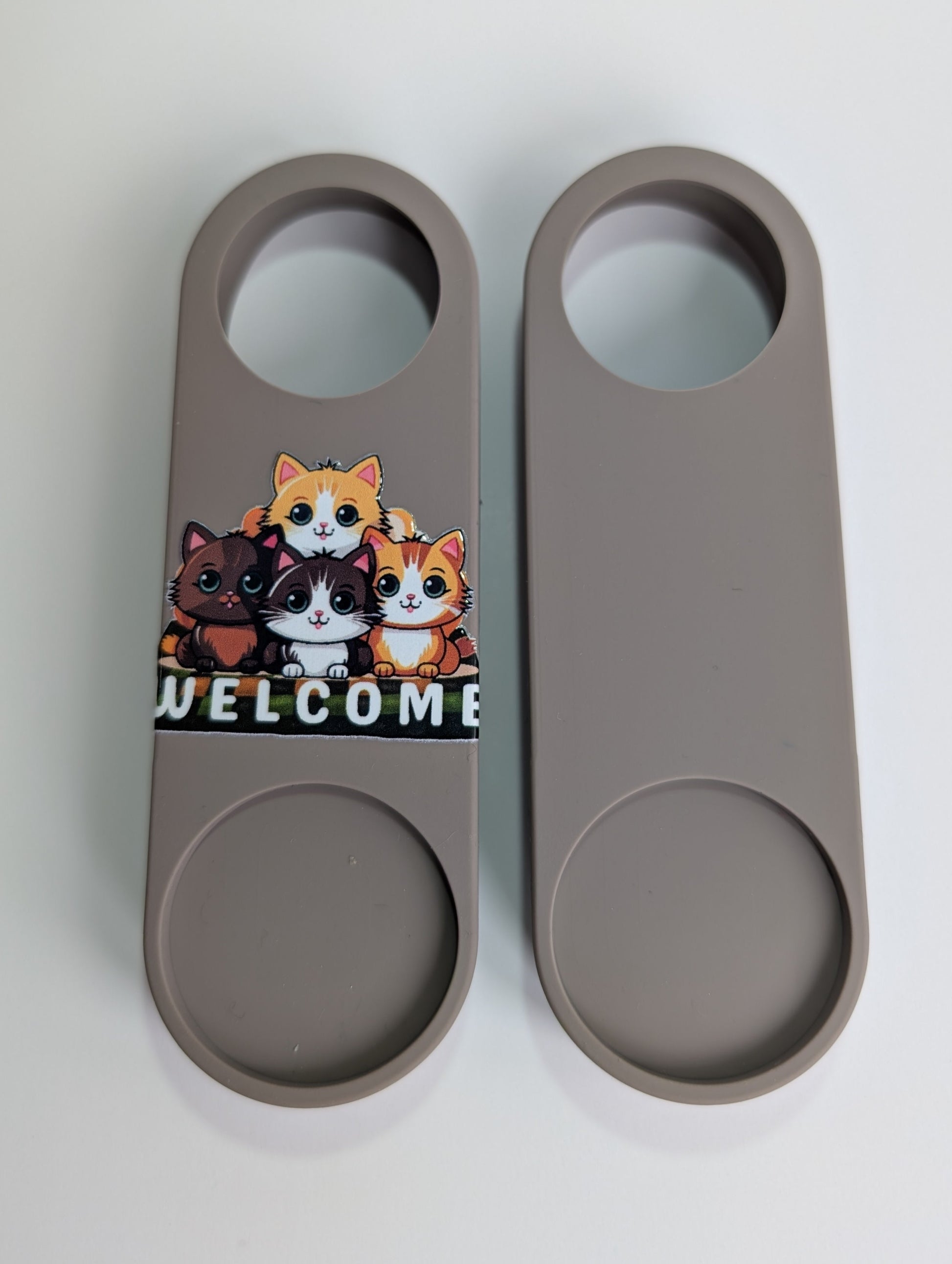 Two gray door openers with cat designs on a white background