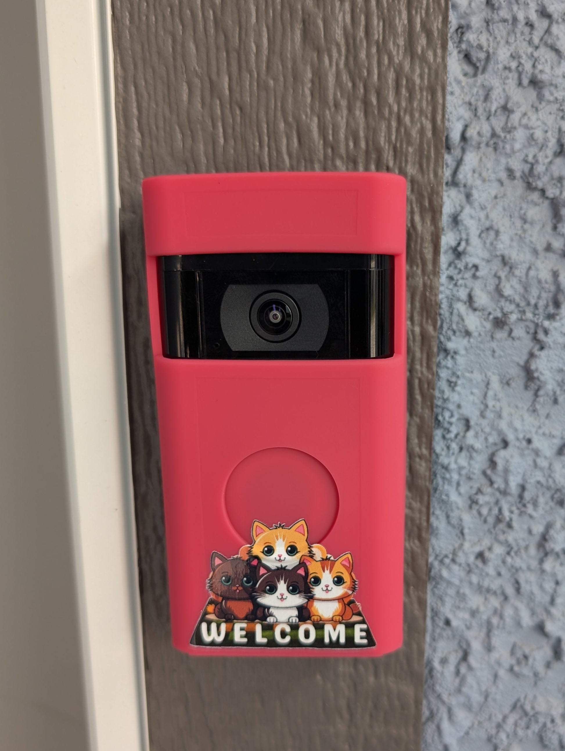 Red doorbell camera with cartoon designs on a textured wall.